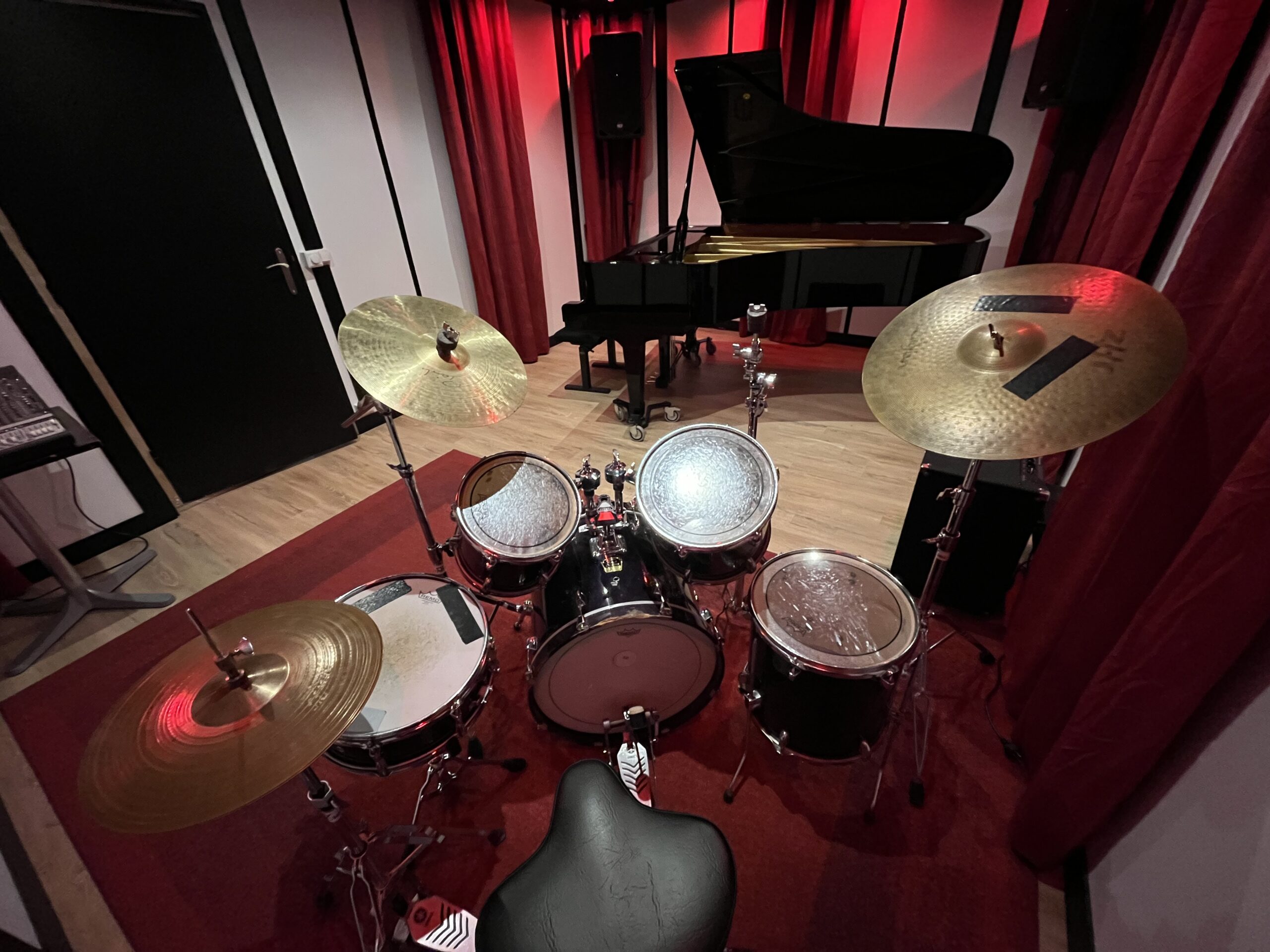 Vue depuis la batterie vers le piano à queue dans le studio de répétition piano, aux portes de Paris.
